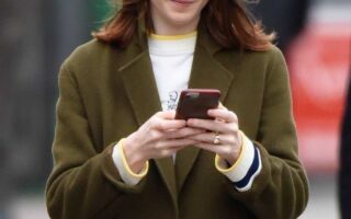 Rose Leslie Smiling While Looking at her Phone and Listening to Music in London