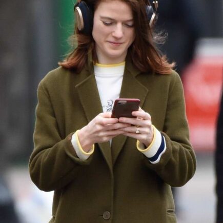 Rose Leslie Smiling While Looking at her Phone and Listening to Music in London