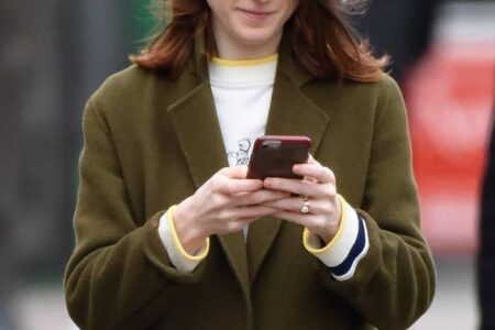 Rose Leslie Smiling While Looking at her Phone and Listening to Music in London