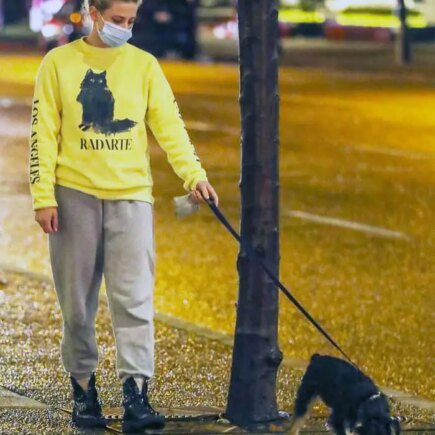 Lili Reinhart in the Yellow Sweatshirt as She Takes her Dog Out for an Evening Stroll