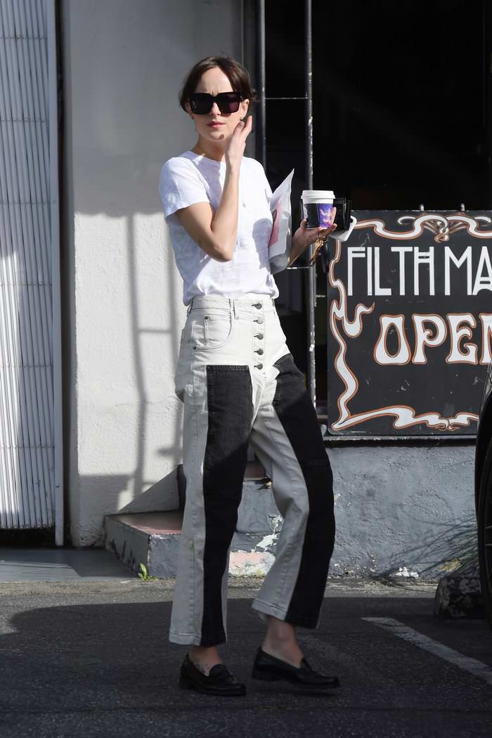 dakota johnson in denim jeans with black panels on the legs as she goes for a coffee 3