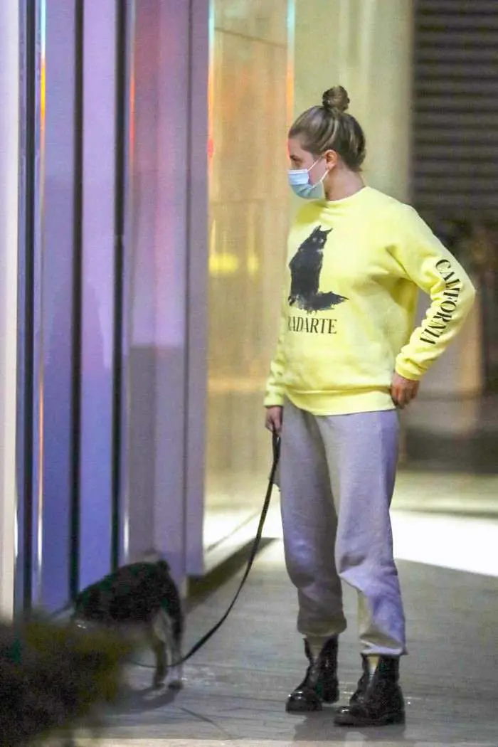 lili reinhart in the yellow sweatshirt as she takes her dog out for an evening stroll 1