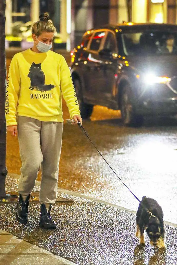 lili reinhart in the yellow sweatshirt as she takes her dog out for an evening stroll 2