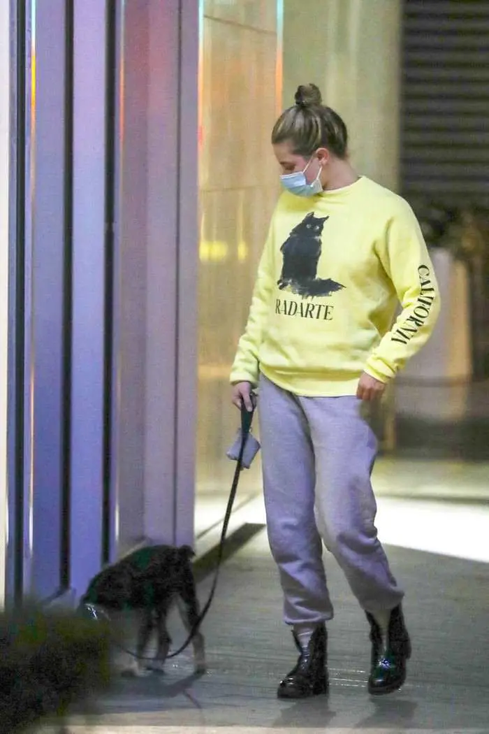 lili reinhart in the yellow sweatshirt as she takes her dog out for an evening stroll 4
