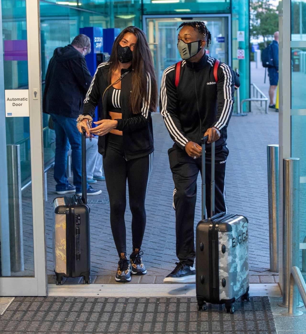 rebecca gormley in a black tracksuit with her bf at newcastle airport 1